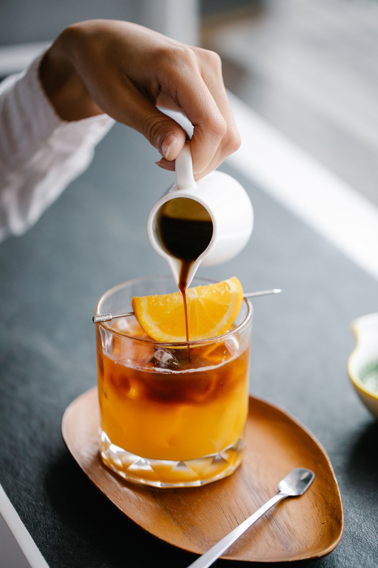 Coffee being poured over orange juice and ice
