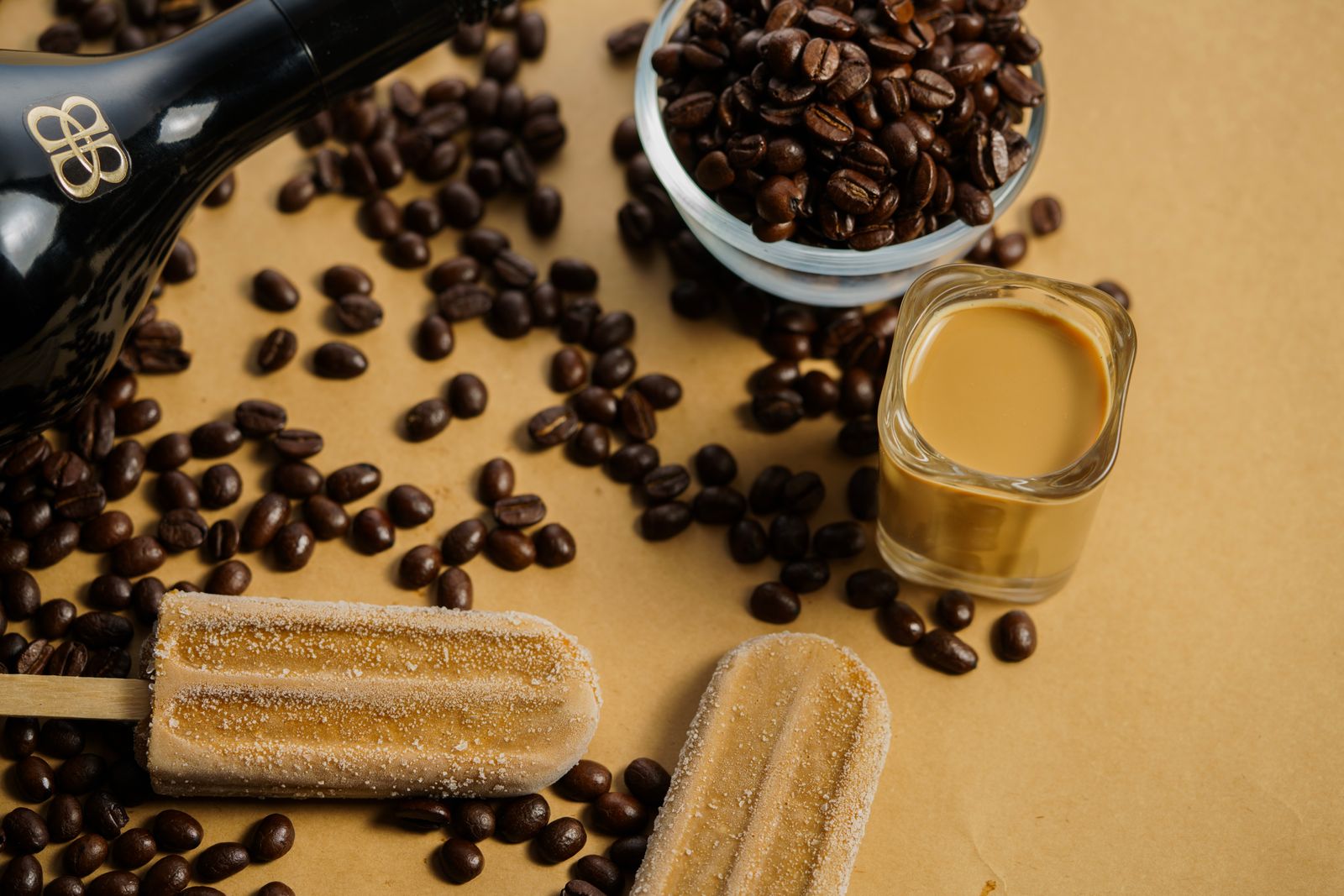 Coffee popsicles with coffee beans on a studio surface
